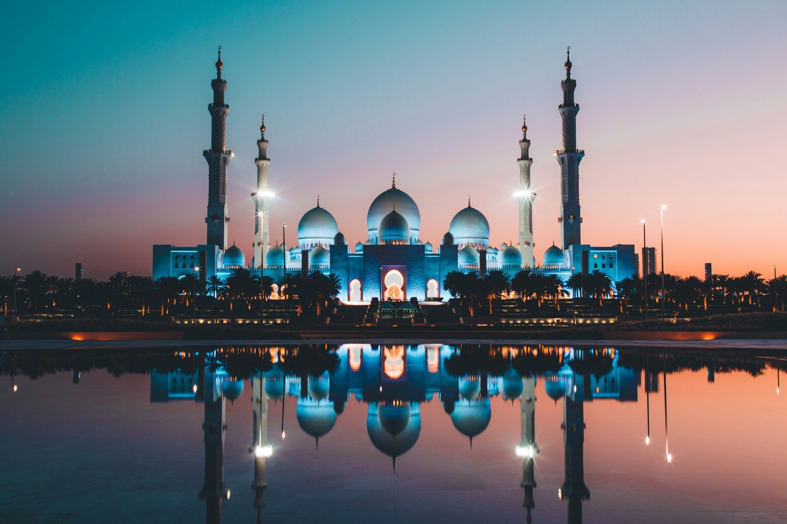 Sheikh Zayed Grand Mosque reflected in the pools at dusk