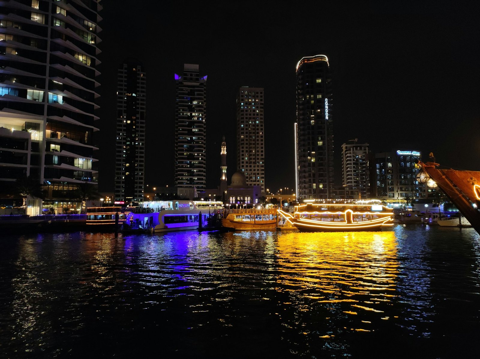 Cruise boats lit up on Dubai Marina at night