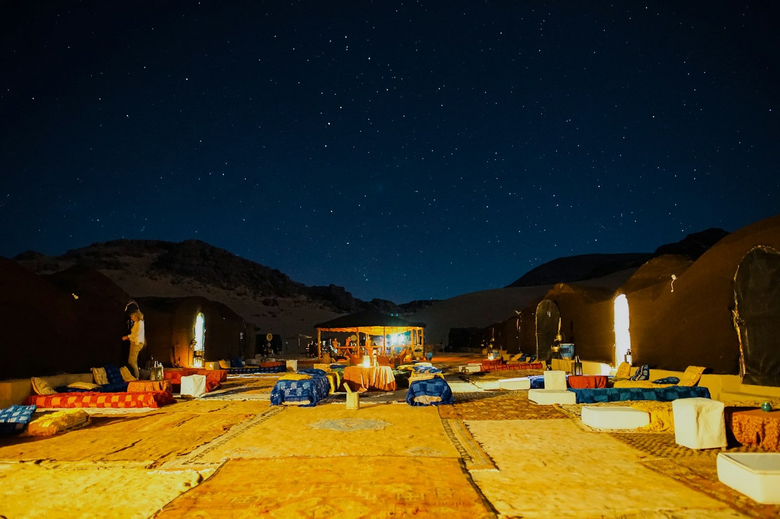 Bedouin-style desert camp lit up at night under the stars near Dubai