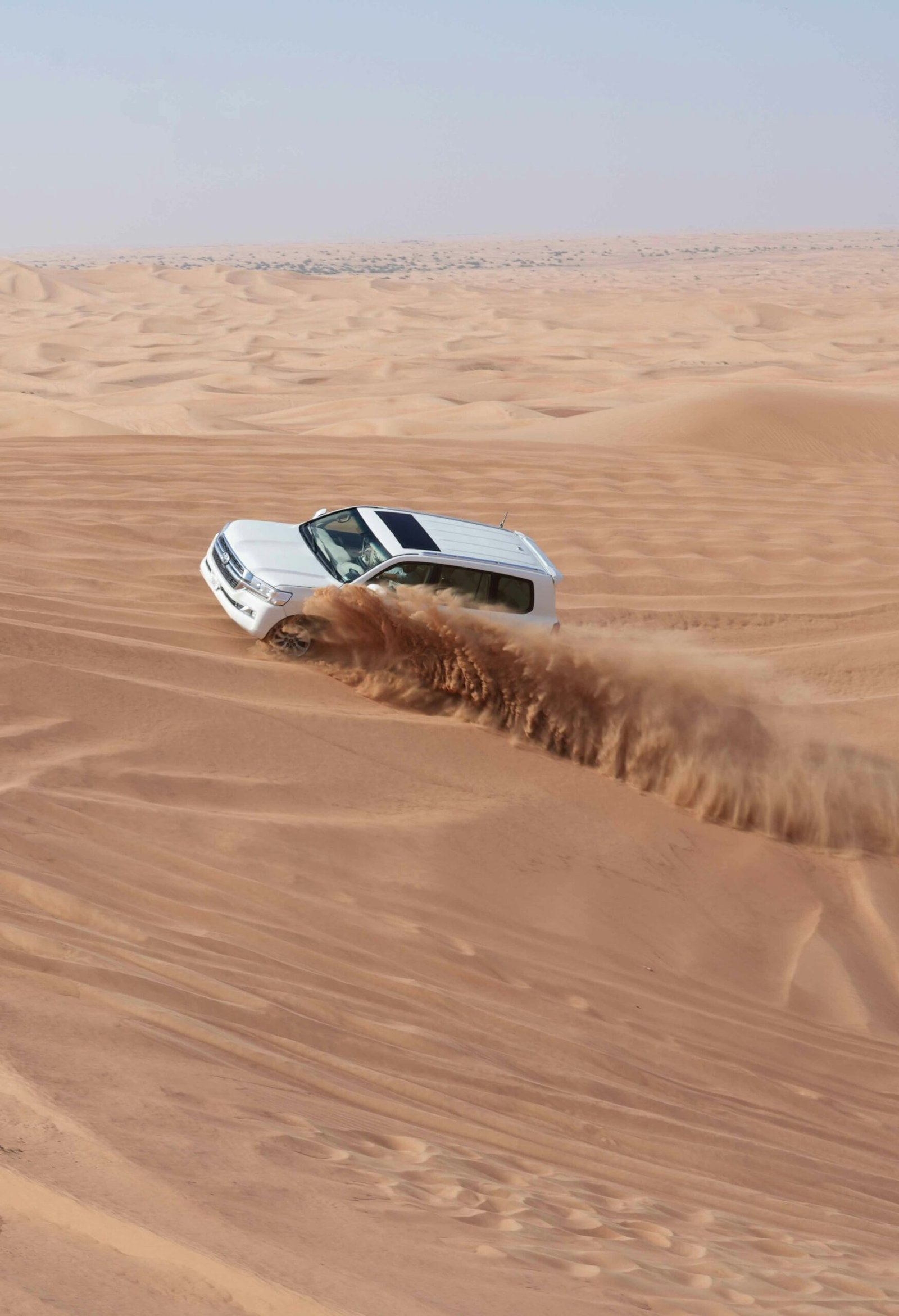 4x4 dune bashing through golden sand on a morning desert safari in Dubai