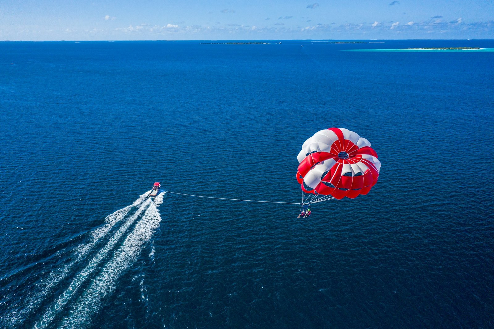 Parasail towed by a speedboat over the blue sea