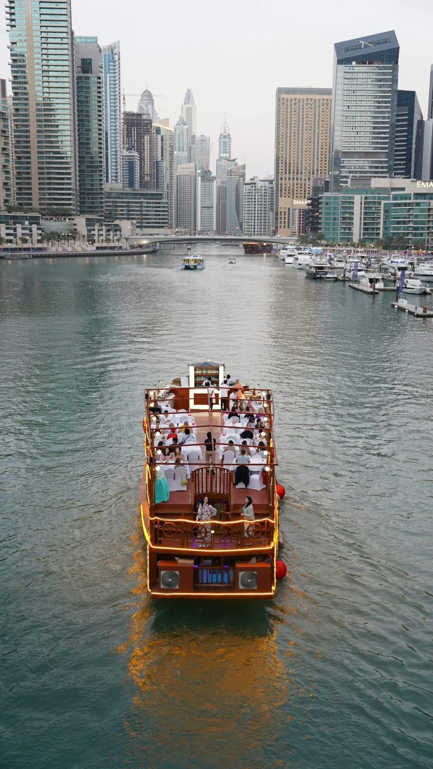 Guests dining on the deck of a dinner cruise in Dubai Marina